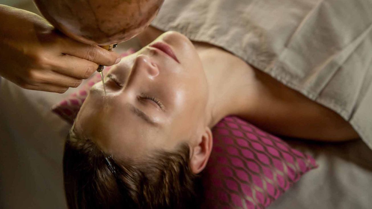 massage shirodhara sur le visage d'une femme